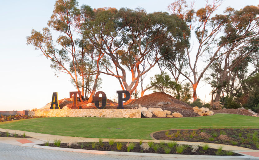 Front entrance of Atop land estate in Beeliar which has been designed around the site's existing typography including Tuart Trees retained at its highest point along with nature play areas for discovery play and meandering walking trails